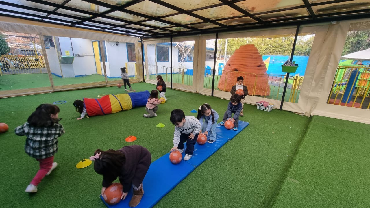 Niños en actividades de psicomotricidad en el patio cubierto de Kangaroo House